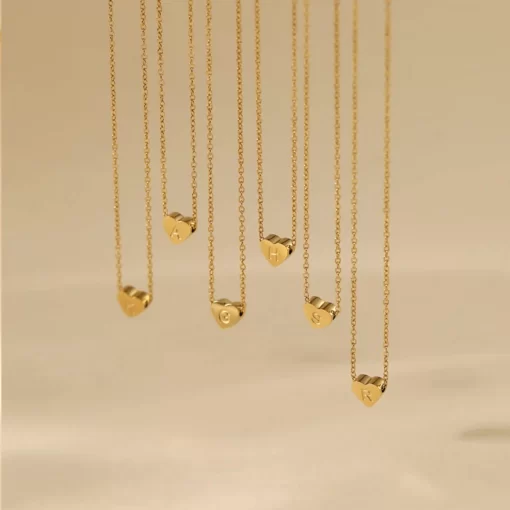 a few Gold heart initial necklace dangling